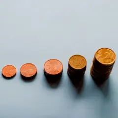 Rosnące stosy monet euro od 1 do 20 centów symbolizują waloryzację i rewaloryzację wartości pieniądza.