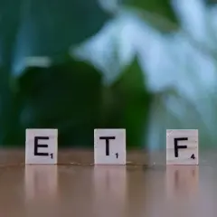 Litery ETF na drewnianych klockach symbolizują inwestycje, które mogą pomóc w nauce, jak zarabiać na giełdzie.