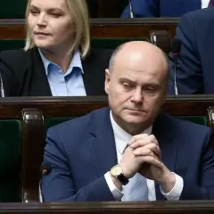Poseł z zamyśloną miną, w garniturze, siedzi w ławach sejmowych. Czy to zapowiedź bankructwa Polski?