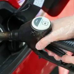 Tankowanie diesla. Ręka w rękawiczce trzyma pistolet paliwowy. Prognoza ceny ropy może wpłynąć na koszty.