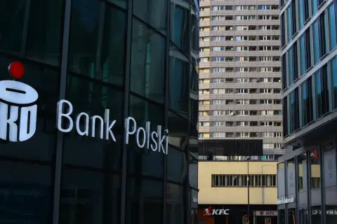 Logo PKO Bank Polski na szklanej fasadzie. W tle blok mieszkalny i KFC. PKO BP rekomendacje.