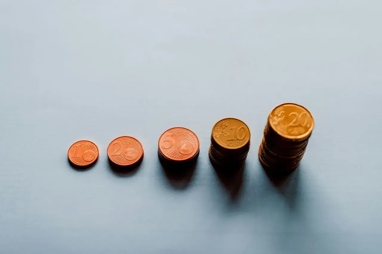 Rosnące stosy monet euro od 1 do 20 centów symbolizują waloryzację i rewaloryzację wartości pieniądza.