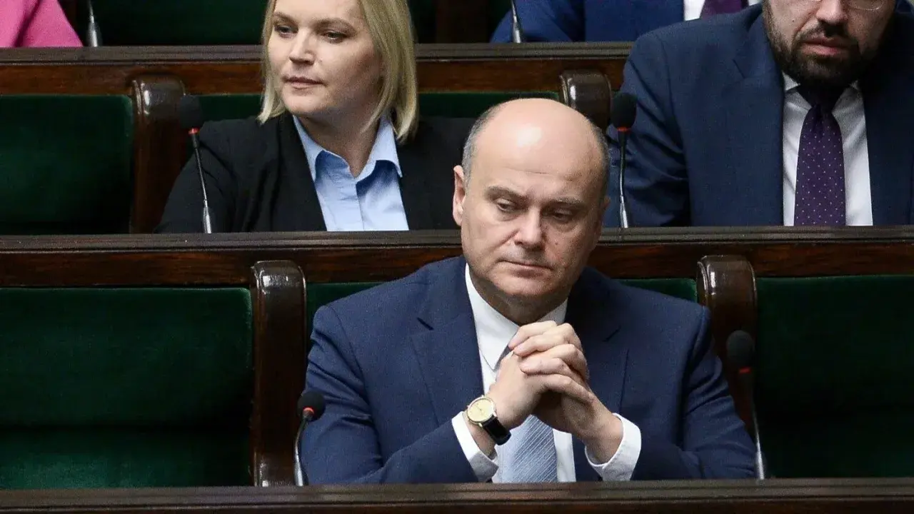 Poseł z zamyśloną miną, w garniturze, siedzi w ławach sejmowych. Czy to zapowiedź bankructwa Polski?