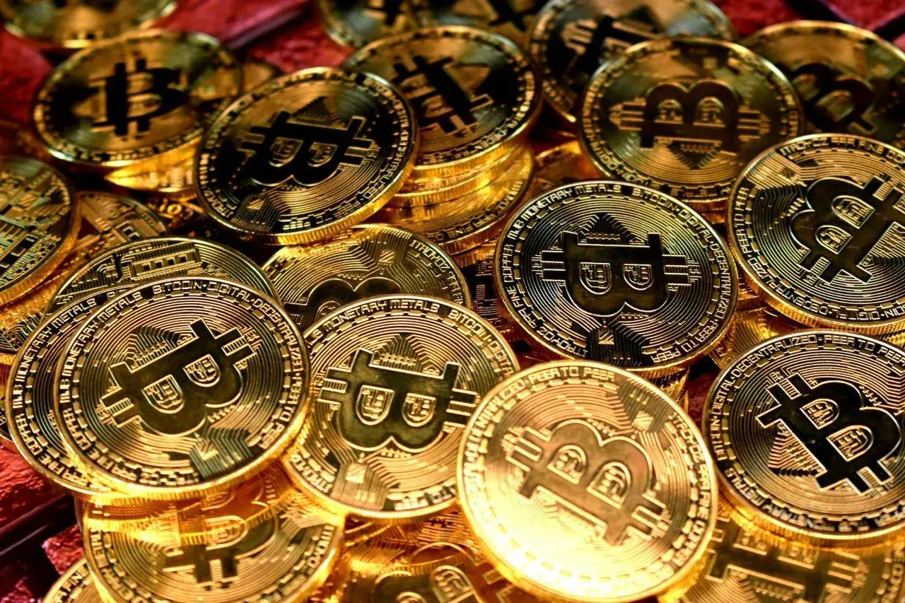 Złote monety z symbolem Bitcoina, symbolizujące jego wartość.
